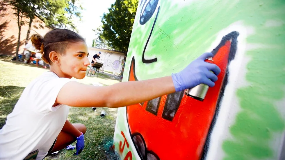 Jasmine Eriksson, 12 år, sprayar röd färg i munnen på sin graffiti.