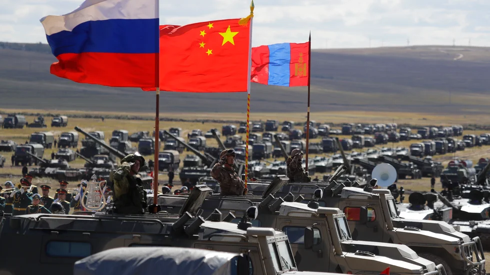 Ryska, kinesiska och mongoliska flaggor vid militärövningen Vostok 2018. Det året deltog 300|000 ryska soldater.
