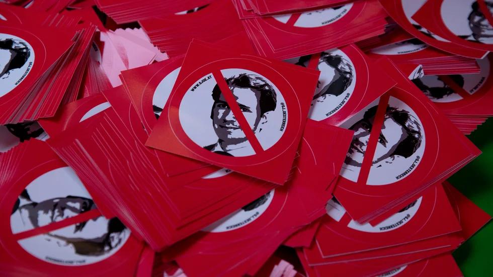 Klistermärken som delades ut vid en demonstration i Österrikes huvudstad Wien dagen efter avslöjandet om att landets förbundskansler Sebastian Kurz misstänks för delaktighet i en korruptionshärva. Arkivbild.