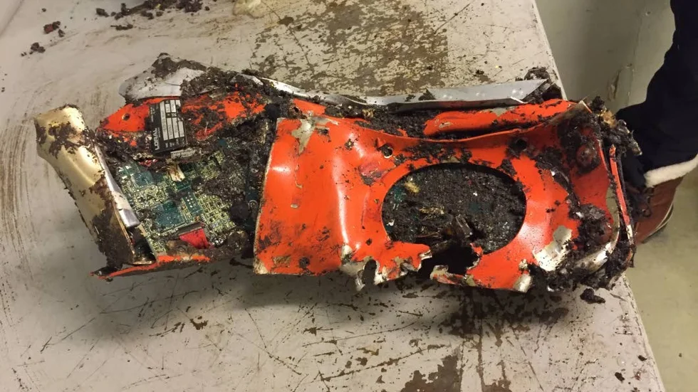 Orange. Den så kallade svarta lådan är i verkligheten orange. I det runda hålet skulle minnesenheten ha legat. Den hittades dagen efter att lådan återfunnits.