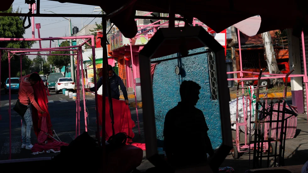 Gatuförsäljare förbereder sig för en arbetsdag på en marknad i Mexico City. Arkivbild från i slutet av mars.