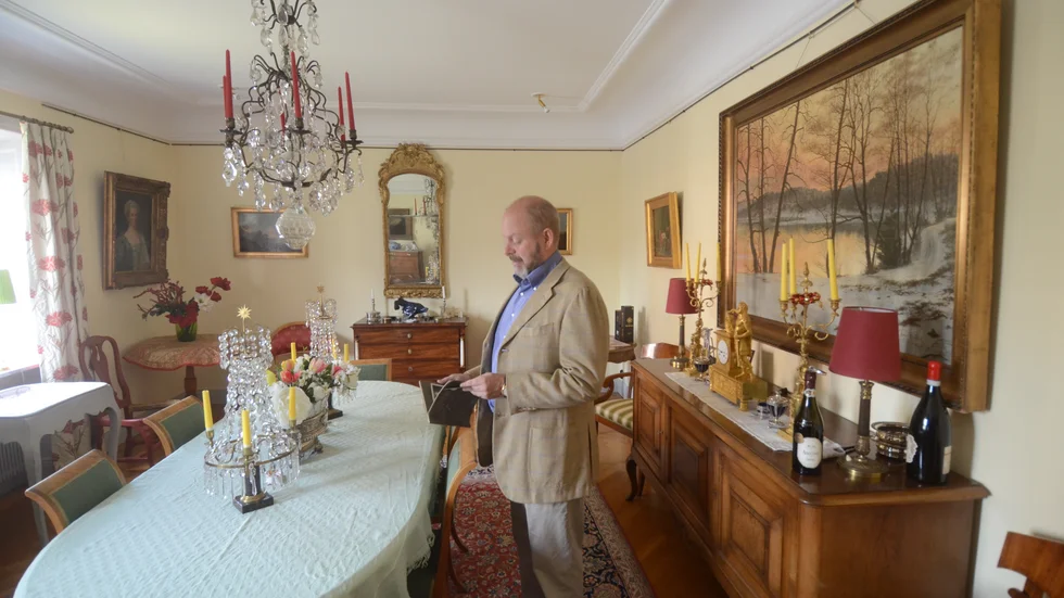 Gustaf Larsson tittar i albumet med bilder över hur huset såg ut när hans farfar ägde det. När han själv blev husets ägare renovera han och Ylva Larsson huset med utgångspunkt från bilderna.