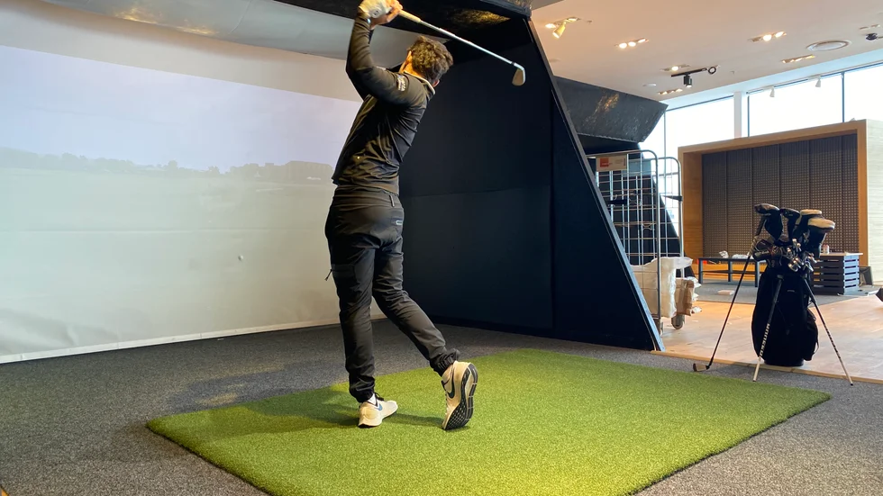 Anton Karlsson, som arbetar på Indoor Golf, testar en av banorna, där kunder ska kunna spela golf året om.