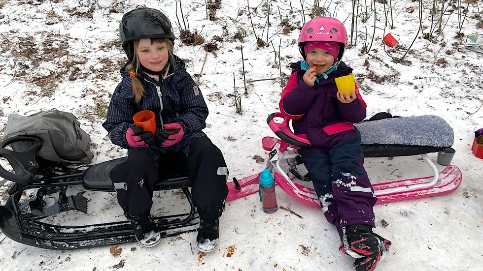 Novalie Baltzer, 6 år, och Wilma Händén, 4 år, tog en paus i pulkaåkandet och styrkte sig med varm choklad och kex.