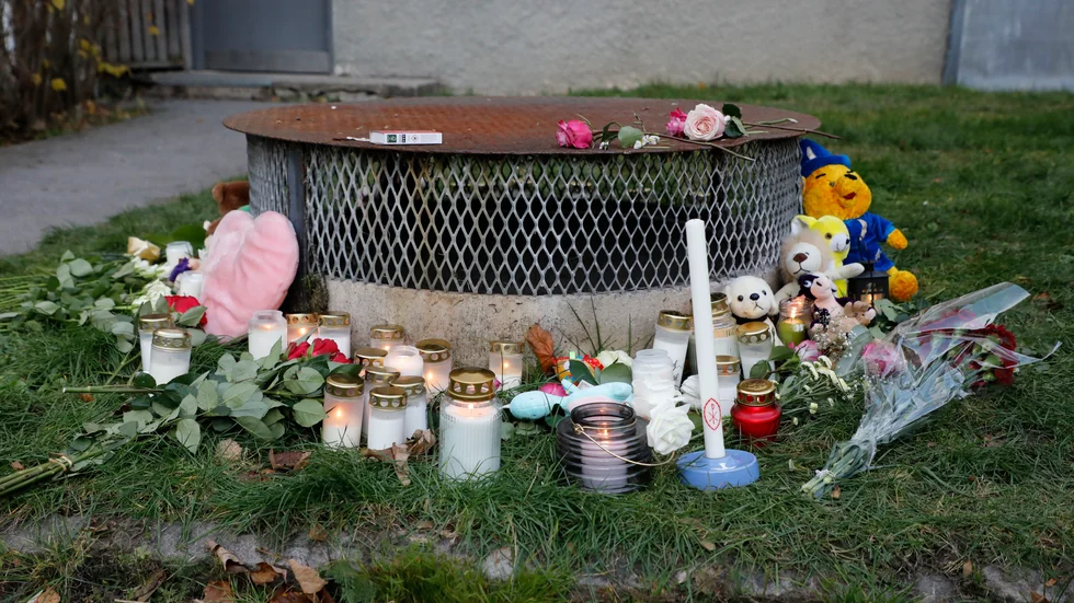 Gosedjur, blommor och ljus vid den plats där två barn hittades med livshotande skador utanför ett bostadshus i Hässelby i höstas. Ett av barnen avled av sina skador. Arkivbild.