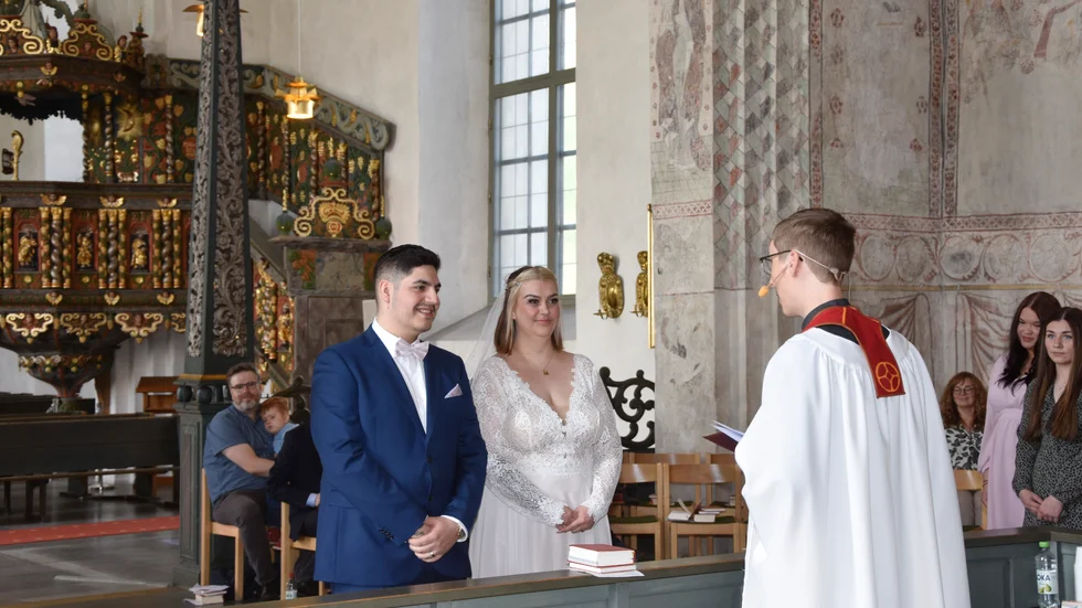 Brudparet Elias Sundvall och Sofia Wanhatalo lyssnar till prästen Petter Edberg.