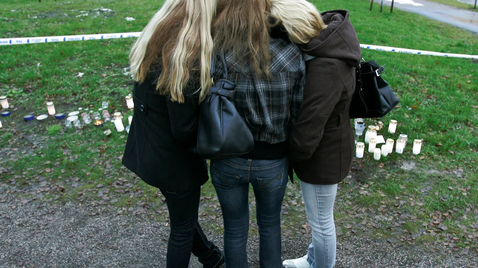 Tre elever tröstar varandra utanför skolan i Jokela, där nio personer dödades i en skolskjutning 2007. Arkivbild.