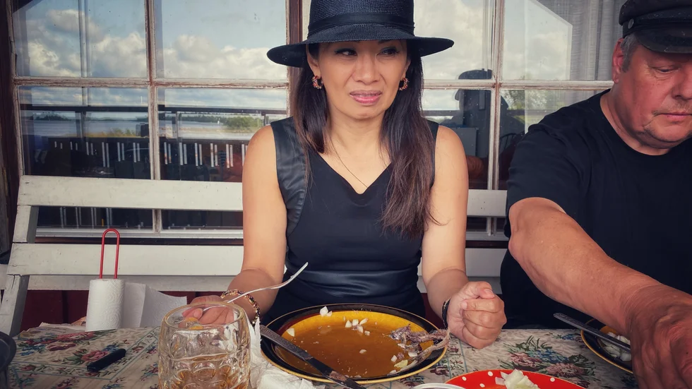 UNT-reportern Jeanina Santiago testade surströmming i Hästskär på Hållnäshalvön. Till höger matrosen Jocke Berg.