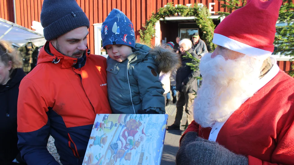 Alla barn fick en julkalender av tomten Bosse Karlsson. Här är det Frans, 3, som får sin klapp, sittande på pappa Sebastian Edengrens arm.