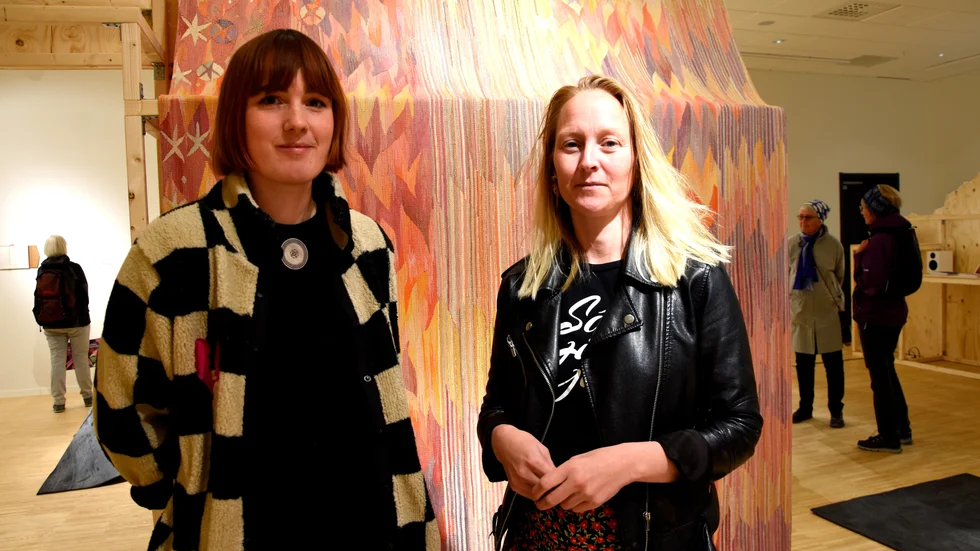 Paulina Granat och Maria Ragnestam, curatorer för utställningen "Fragment" som invigde den nya konsthallen i Kirunas kulturhus. På bild framför Barbro Nilssons textila verk "Solvägen" som hängt i en skolmatsal. "En osynliggjord konstnär", menar de.