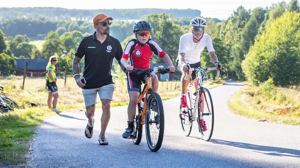 Motala AIF:s cykels ordförande Felipe Sanhueza ger Team LeWa sports Stina Gustavsson en hjälpande hand i den brantaste delen av backen upp till Övralid. Morfar Mats Nilsson får ta i för hänga med. Den gemensamma träningskvällen hoppas Sanhueza på sikt ska leda till att locka fler till cykelsporten. 