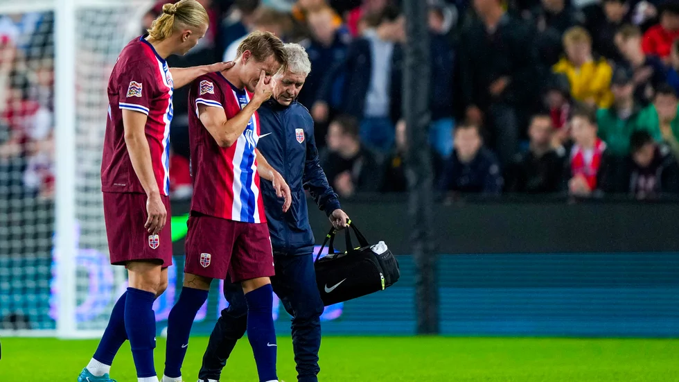 Skadade Martin Ødegaard får hjälp av planen av Erling Braut Haaland. Arkivbild.