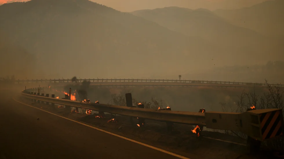 En tjock dimma av brandrök syns i området där storbranden härjar utanför Los Angeles. Bild från lördagen.