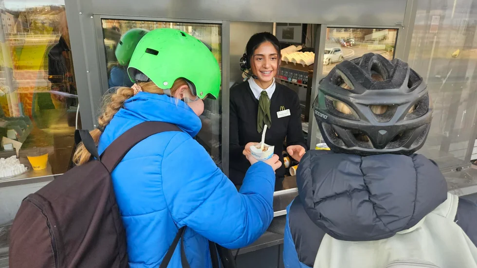 Två hungriga cyklister stannar till i restaurangens drive-in för en beställning. Natalee Khalaf, arbetsledare serverar dem.
