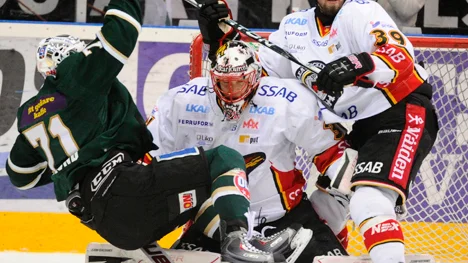 KARLSTAD 2011-02-01 Färjestads Christian Berglund faller framför Luleåmålvakten Anders Nilsson med Luleås Robin Jonsson till höger under tisdagens elitseriematch i ishockey mellan Färjestad BK och Luleå HF på Löfbergs Lila Arena i Karlstad.
Foto Lars Hedelin / SCANPIX / Kod 10074