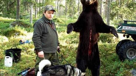 Daniel Jonsson och hunden Myllys med den skjutna björnhannen som vägde 167 kilo innan slakt. FOTO: Erik Ögren