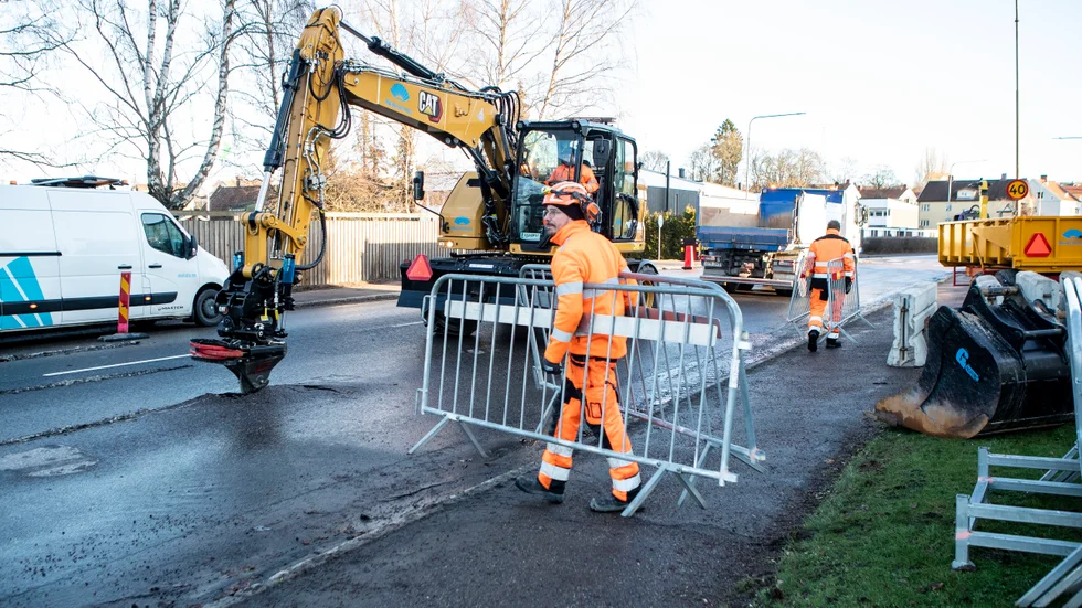 Sebastian Dahlqvist bär ut avspärrningsstaket runt arbetsområdet på Drottninggatan. Hur allvarlig vattenläckan vet arbetslaget först när de grävt sig ner till rörledningen. 