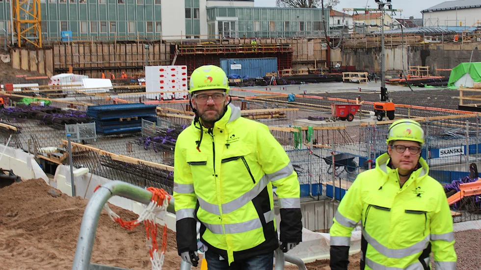 Perry Essén och Henrik Karlsson på väg upp ur gropen där den nya psykkliniken vid Västerviks sjukhus tar form.