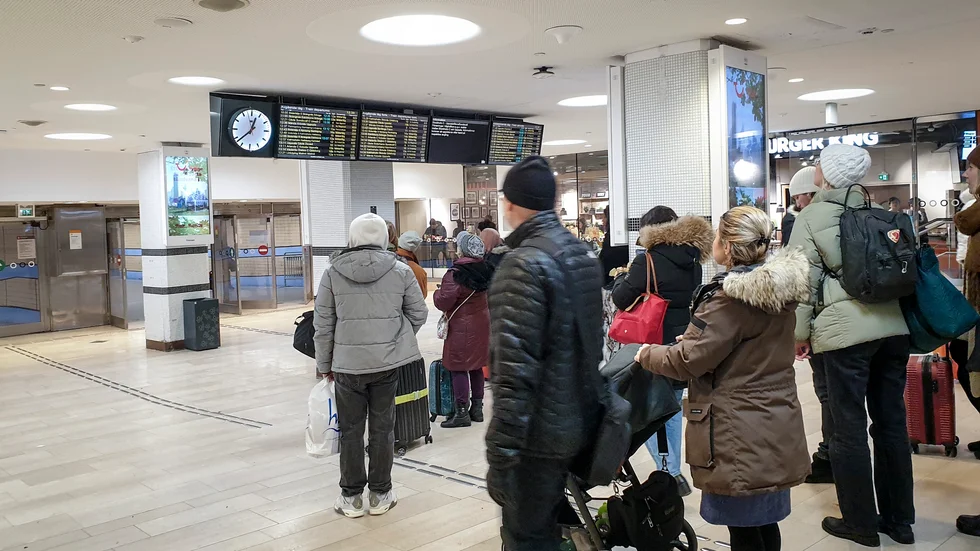 Resenärer tittar på avgångstavlorna på Stockholms central den 28 november, då tåg försenades på grund av kraftigt snöfall. Arkivbild.