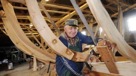Bordläggning. Sture Magnusson fäster de första plankorna i bordläggningen på sitt sista stora byggprojekt. Träbåten ska bli en kutter med ruff och inombordsmotor.