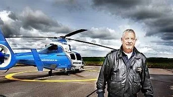 Piloten Kurt Lindblad på Ärna, Akademiska sjukhusets bas för ambulansflyget. I bakgrunden ambulanshelikoptern.