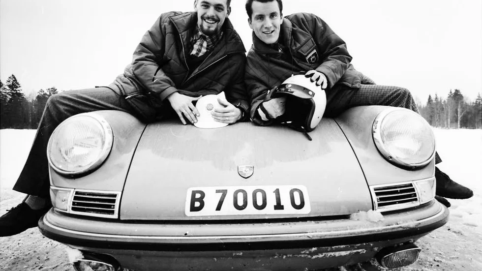 Åke "Bryggarn" Andersson (t h) tillsammans med kartläsaren Bosse Thorszelius sittandes på huven på en Porsche 911.