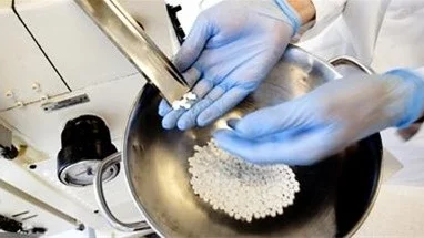 Emil Schwan, produktutvecklare på Orexo, framställer tekniska placebotabletter i en rundlöpande tablettmaskin.