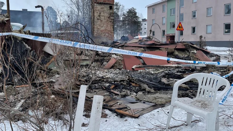 Huset har rasat ihop. Ett dygn efter att elden utbröt flammar det fortfarande i ruinen.