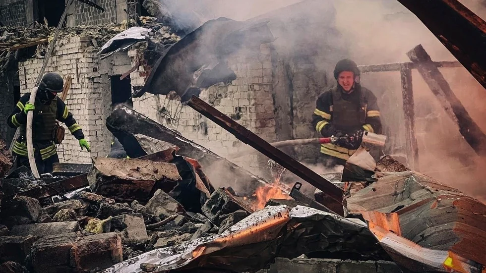 Räddningsarbetare släcker en brand som brutit ut i samband med en rysk attack mot en byggnad i Brovary i utkanten av Kiev.