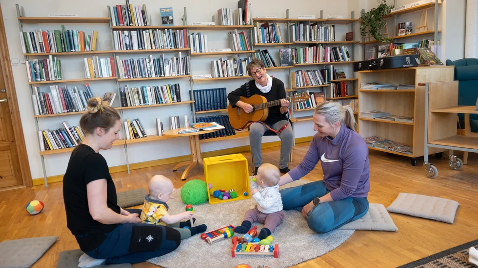 Sångstund på öppna förskolan i Norra Svartbyn. Ellinor Morén med sonen Björn och Madelen Appelgren med dottern Freja i förgrunden. På gitarr: Eva Stenberg.