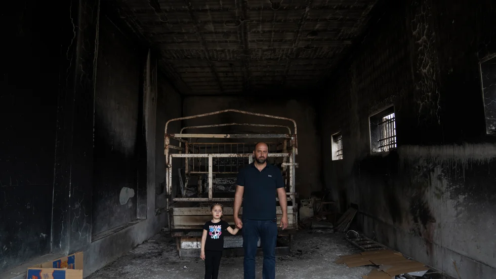 Ibrahim Dawabsha med dottern Ghina i familjens garage, som sattes i brand av bosättare.