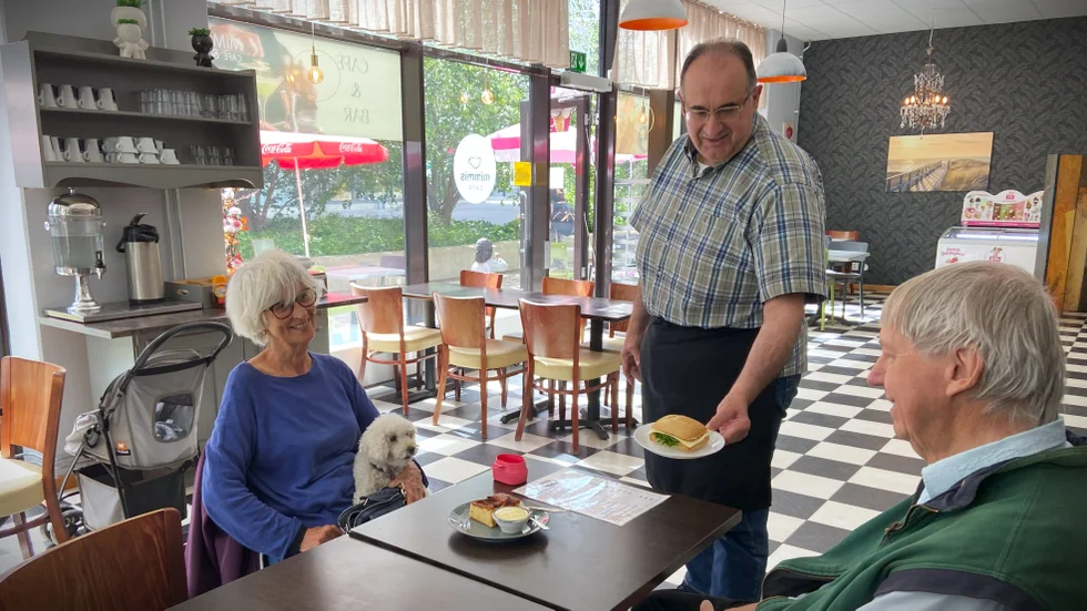 ”Det är jätteviktigt med ett kafé på gångavstånd där det blir en hemkänsla. Att inte behöva ta bussen till stan”, säger Roger Gyllin (till höger) som fikar med Gunilla Stenkula och serveras av ägaren George Barsoum.
