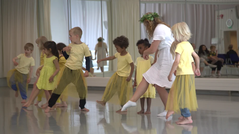 Med gula blomdräkter, glada skratt och kransar i håret, samlades barn och pedagoger för att dansa på Musikhögskolan i Piteå.