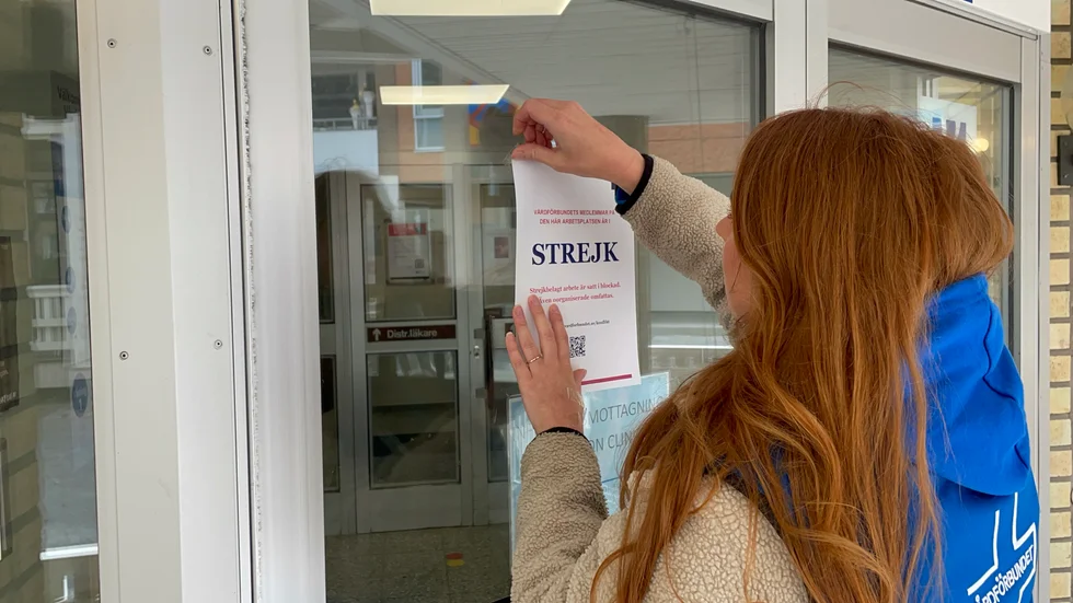 Sofia Andersson, konfliktinformatör på Vårdförbundet, sätter upp informationslappar på dörren för att informera patienterna om att stora delar av personalen på Heimdalls hälsocentral är ute i strejk.