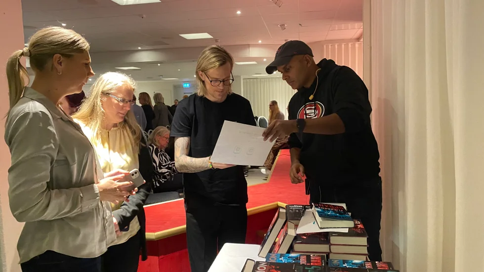 Simon Häggström sålde sina böcker i samband med föreläsningen. Här köper Mikael Bergman en bok. Therese Johansson och Zenitha Ruisla väntade på sin tur.