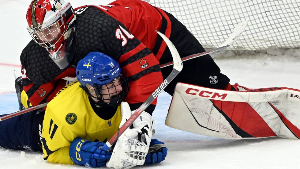 Sverige på fall. Lucas Pettersson hamnar under Kanadas målvakt Carter George i semifinalen i U18-VM.