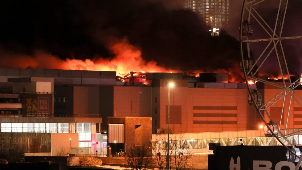 Här brinner Crocus konserthus och galleria i västra Moskva efter terrorattacken på fredagskvällen.
