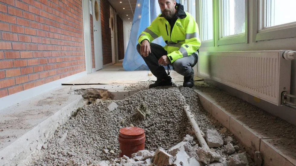 Johan Blomquist vid ett av de hål som tagits upp i golvet på gymnasiet för att man ska komma åt ledningarna, som visade sig innehålla stora mängder kvicksilver och bly.