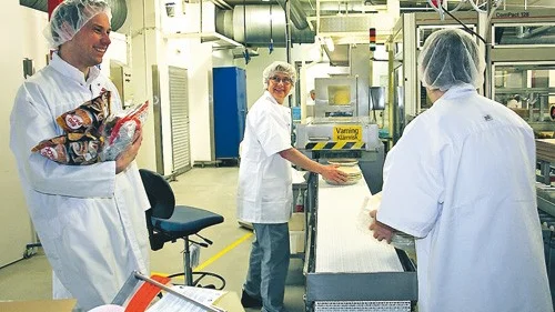 Full fart. Lena Isaksson och Margareta Johansson småpratar med Klas Steenrum (till väster) medan de paketerar pajskal.