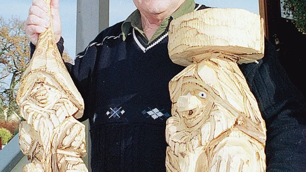 Stig Hansson från stödföreningen visar upp några alster av Matti Immonen, motorsågskonstnären från Vetlanda. Han är en av hantverkarna på årets julmarknad.