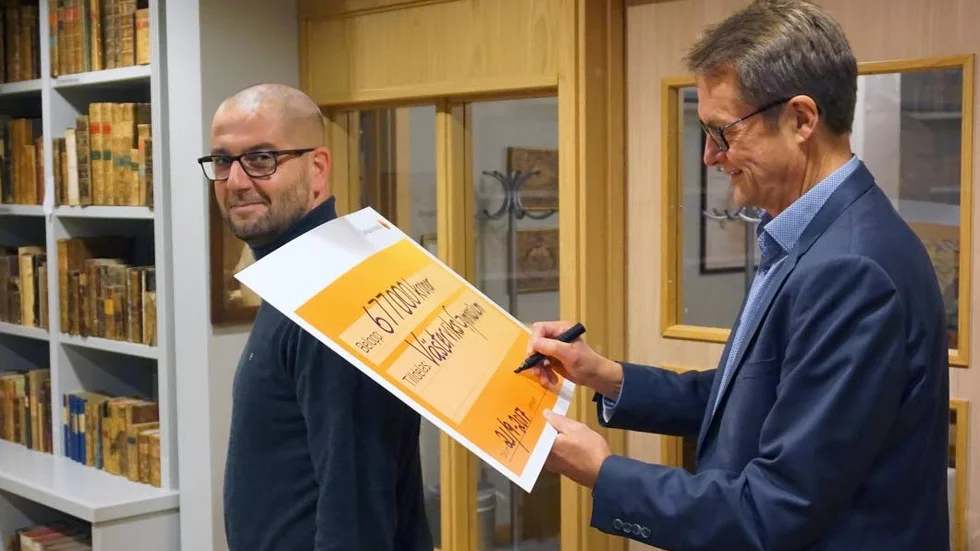 Nöjd mottagare. Sparbanksstiftelsens verkställande tjänsteman Carl-Magnus Mårheden undertecknar checken till gymnasiechefen Jörgen Jonsson.