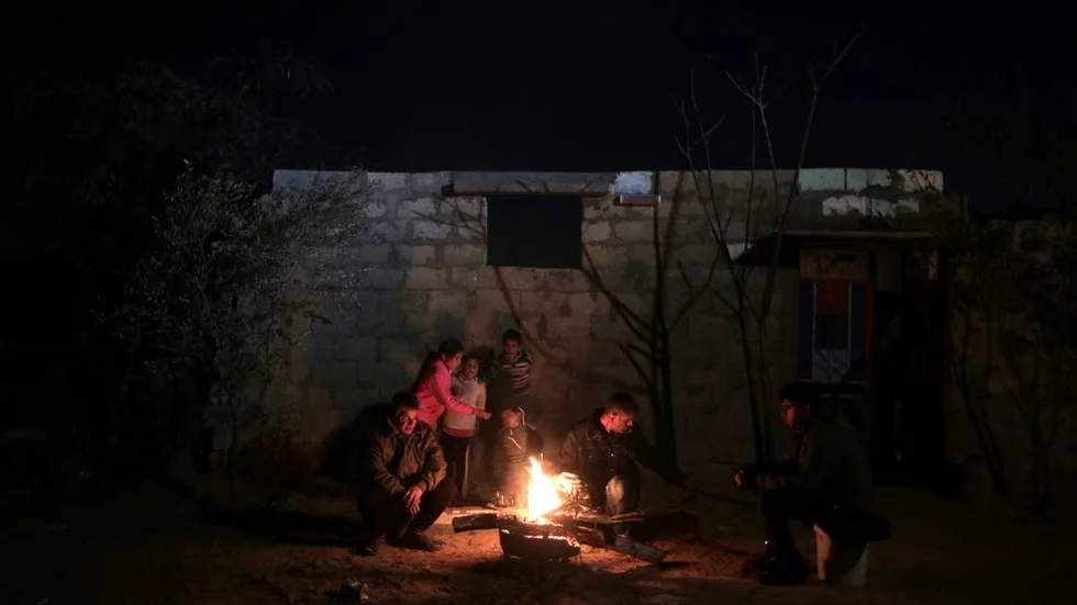 Mörker. En familj i den södra delen av Gaza gör upp eld under ett av de många elavbrotten. Bristen på energi är ett av de stora problemen för befolkningen.
