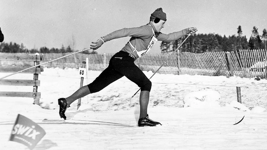 En klassisk bild av Ragnar "Föllinge" Persson från skid-SM i Rättvik 1964. Bilden är förlaga till den staty som rests i Föllinge till skidkungens ära. "Bilden kan ses som en protest mot den förbannade stakåkningen", menar artikelförfattaren Jan-Erik Larsson.