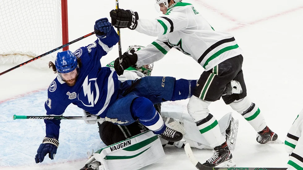 Dallas Miro Heiskanen trycker ner Tampa Bays Brayden Point, över sin egen målvakt.