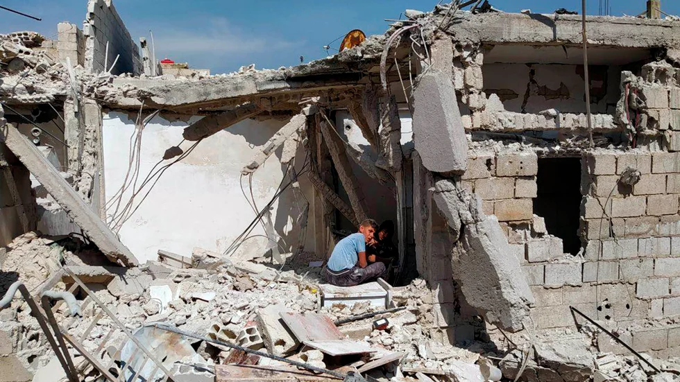 Pojkar leker i en ruin i en förort till det krigshärjade Syriens huvudstad Damaskus.