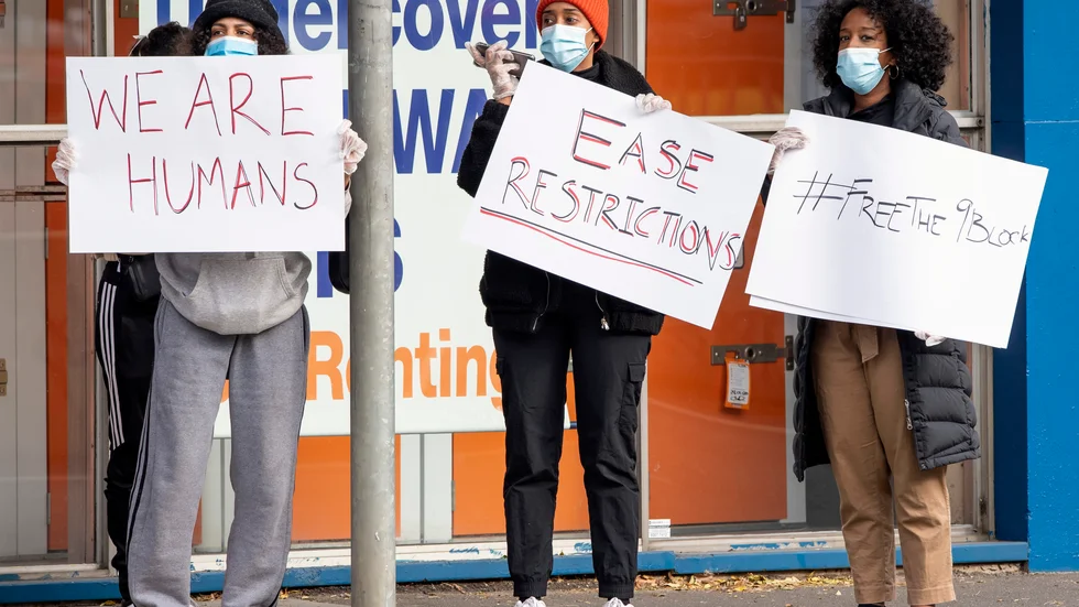 Kvinnor protesterar mot de nya virusrestriktionerna vid ett drabbat bostadskomplex i Melbourne den 6 juli.