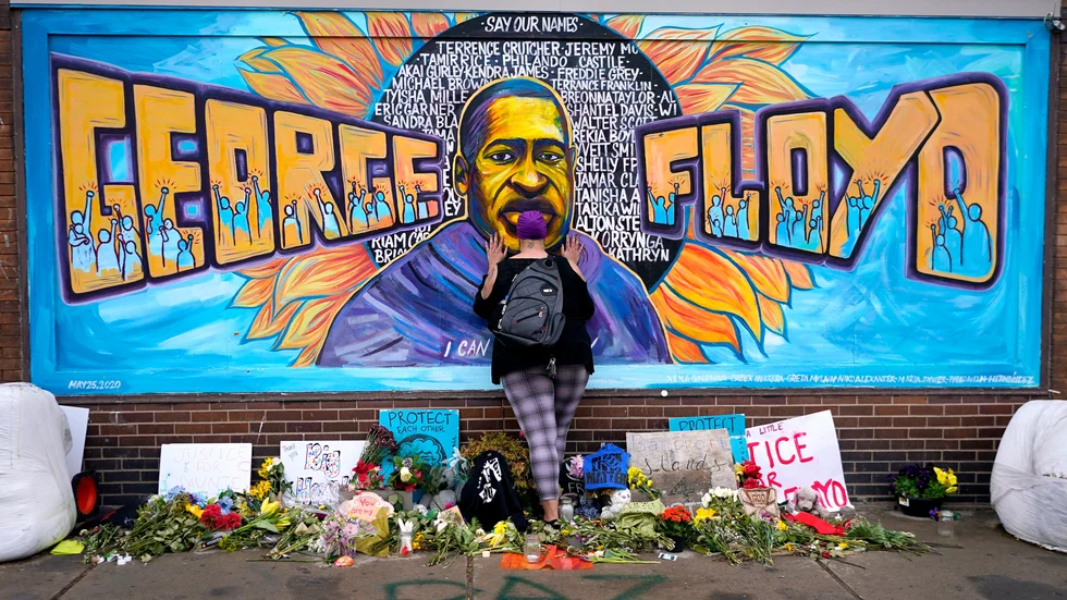 Förbipasserande hedrar George Floyd, som dog i ett våldsamt polisingripande i fjol, i dennes hemstad Minneapolis i USA. Där pågår nu en omröstning om huruvida poliskåren ska finnas kvar i sin nuvarande form.