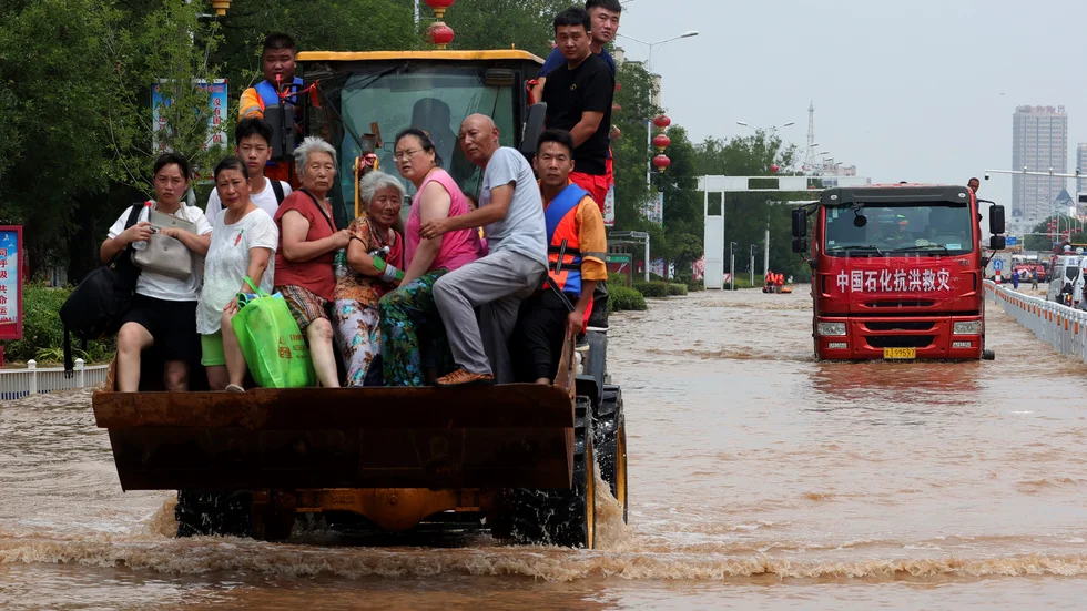 Människor räddas undan översvämningarna i Henan i Kina.