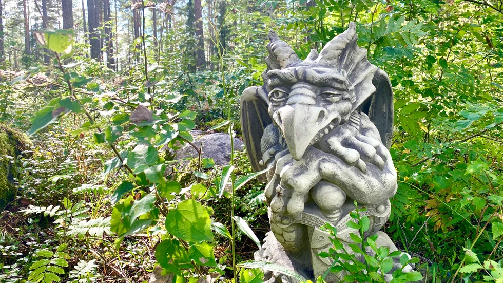 Hans överdimensionerade händer vilar över ett svärd. Med misstänksam blick och ett lömskt leende betraktar han omgivningen.