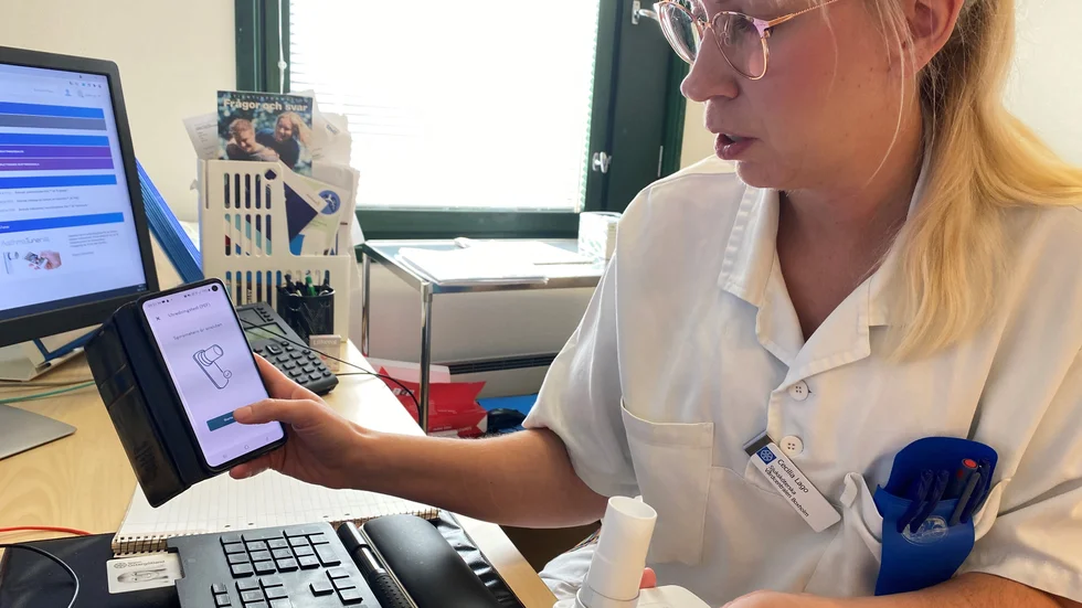 Astmasköterskan Cecilia Lago i Boxholm har precis blåst i den digitala lungfunktionsmätaren, som pratar med en app i mobiltelefonen. Nu kommer värdena upp på skärmen och samtidigt i vårdcentralens dator.